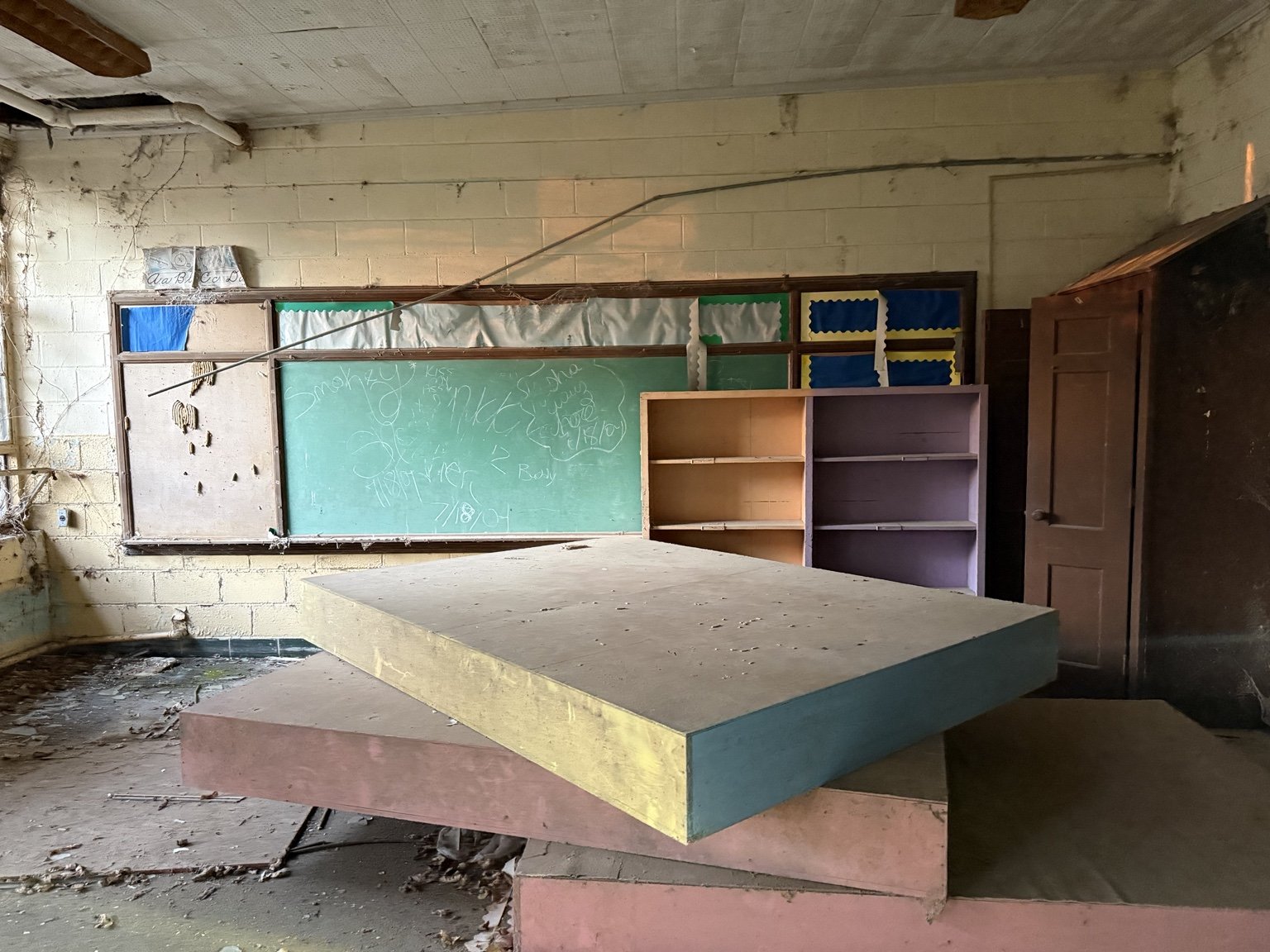 Interior classroom with chalkboard still bearing writing from 2004